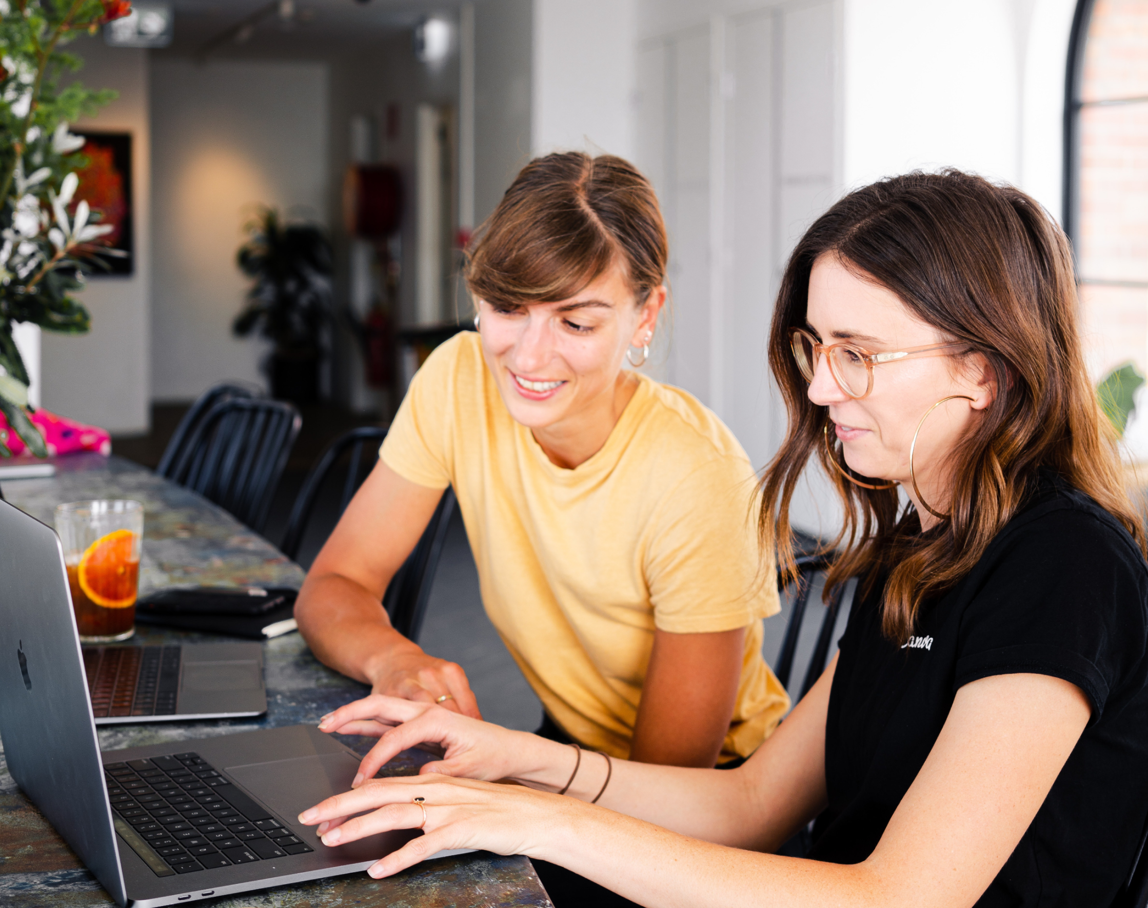 Two female persons typing on computer