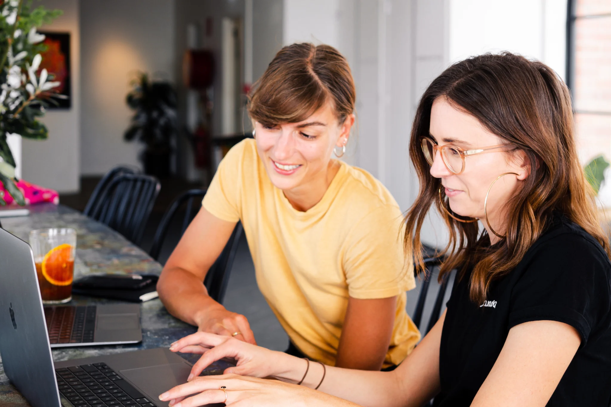 Two female persons typing on computer