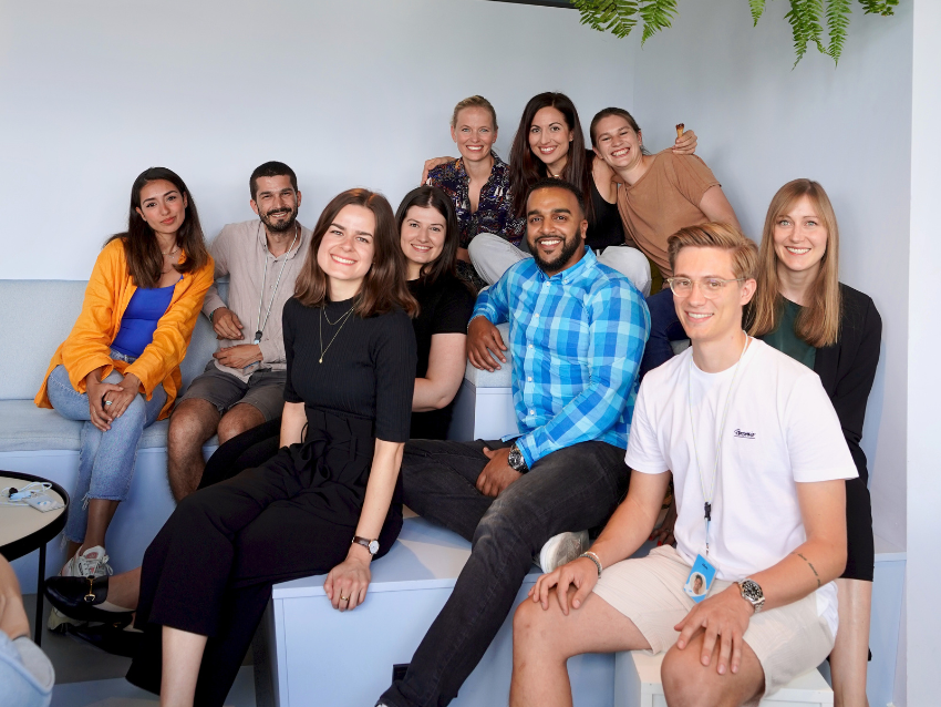 Group of people sitting together, smiling into the camera