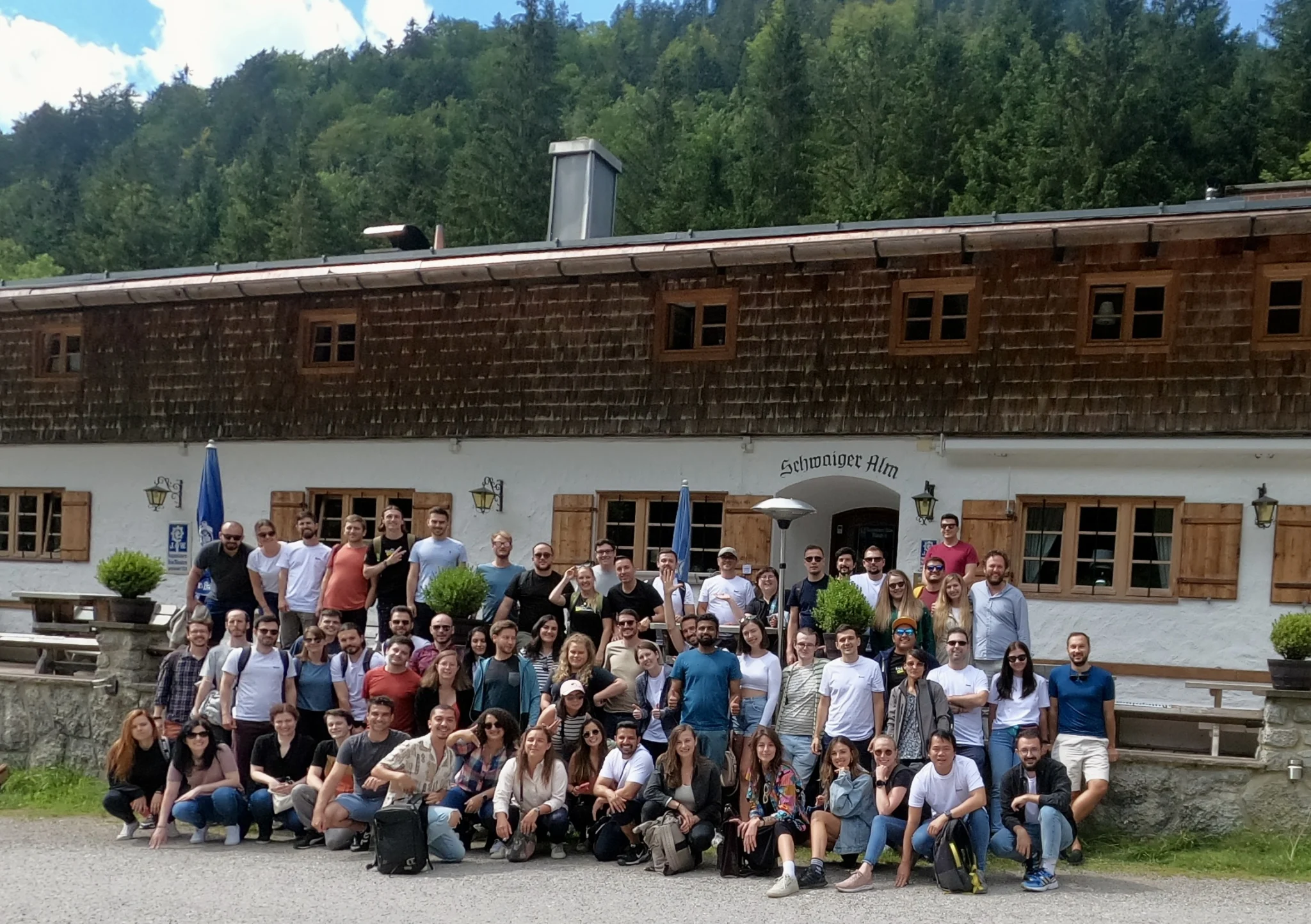 Engineering group picture outside at a team offsite in front of a cabin