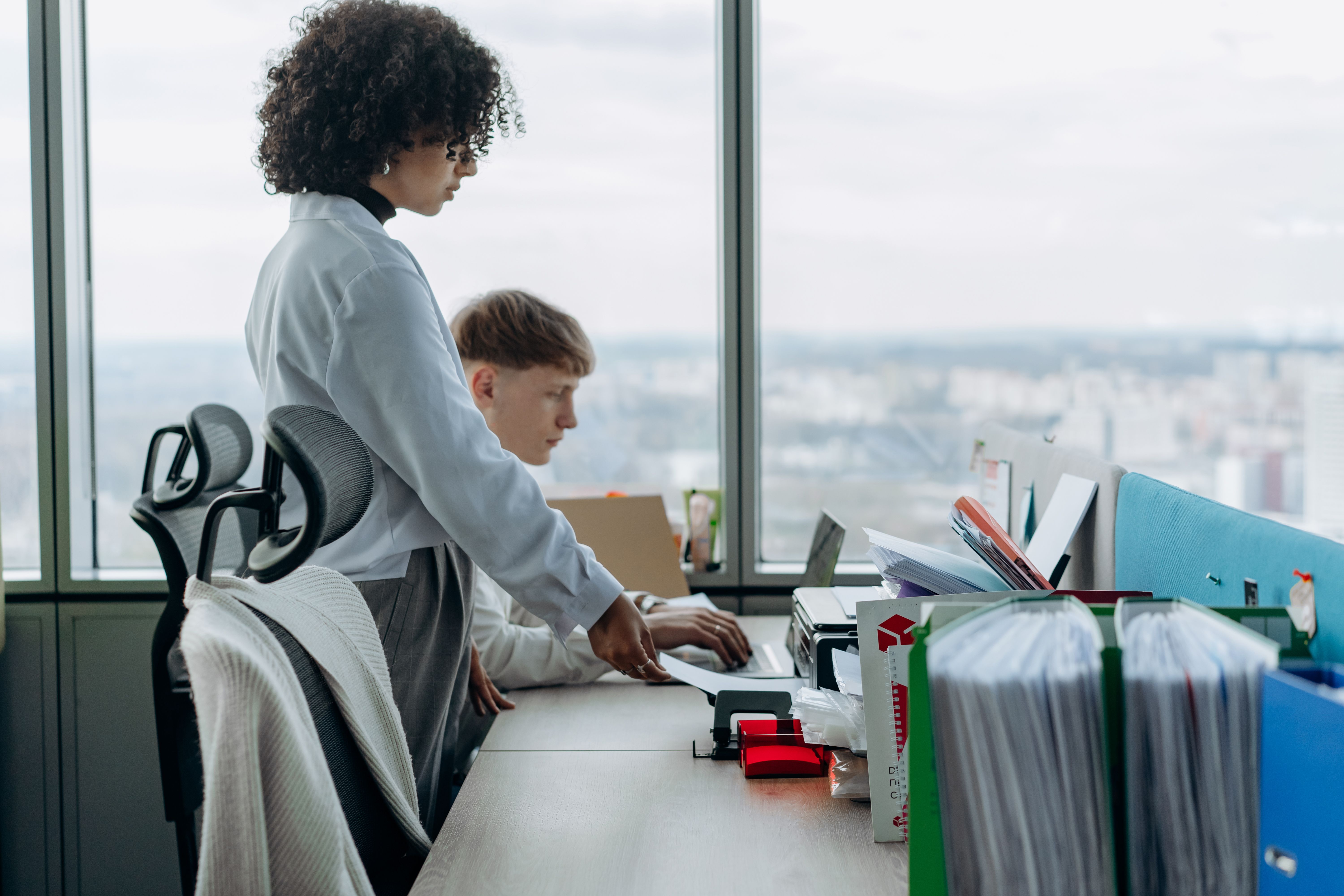 Twee HR-medewerkers werken samen achter een bureau met digitale HR-software voor personeelsadministratie en HR-processen.