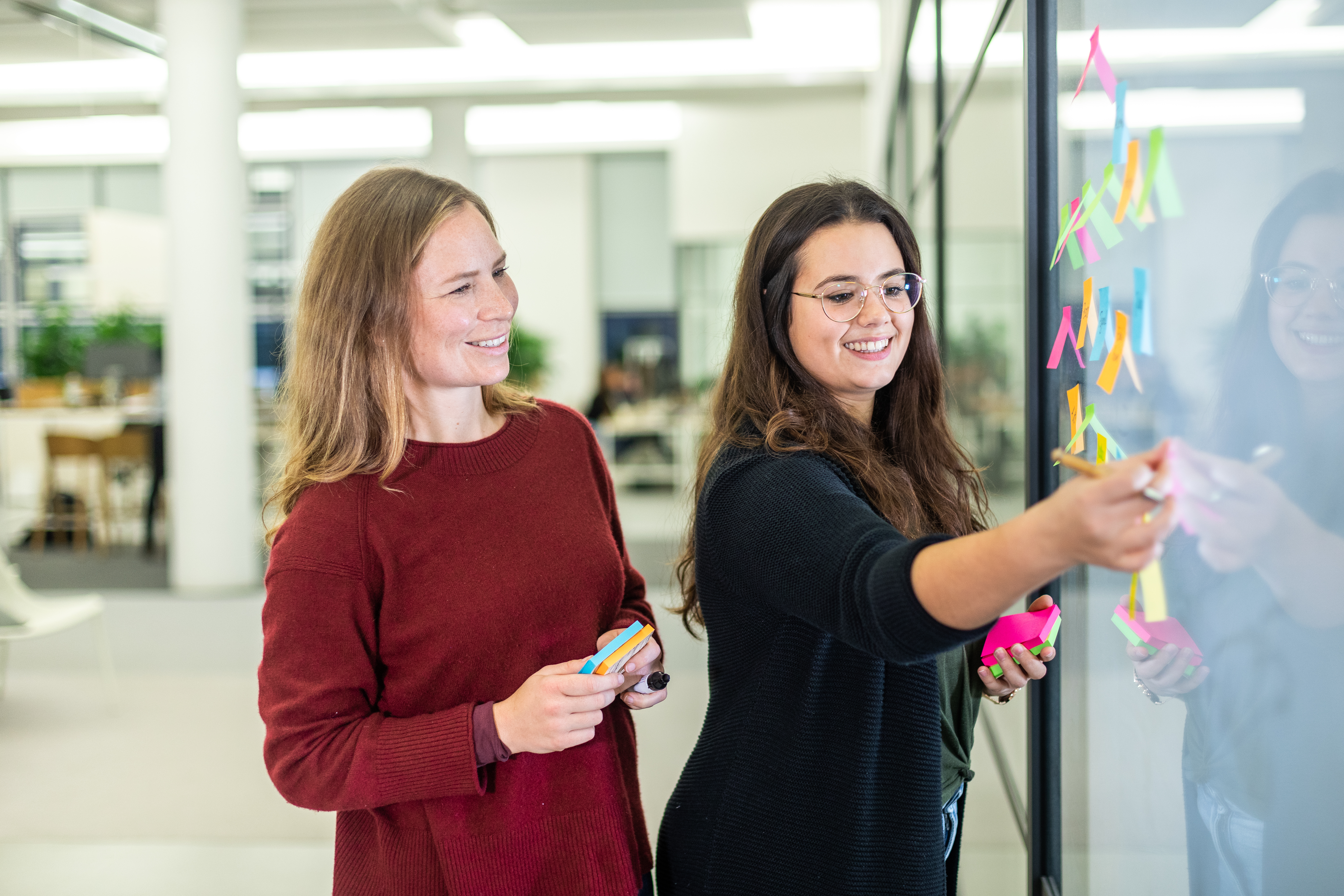 Twee vrouwen werken met plakbriefjes