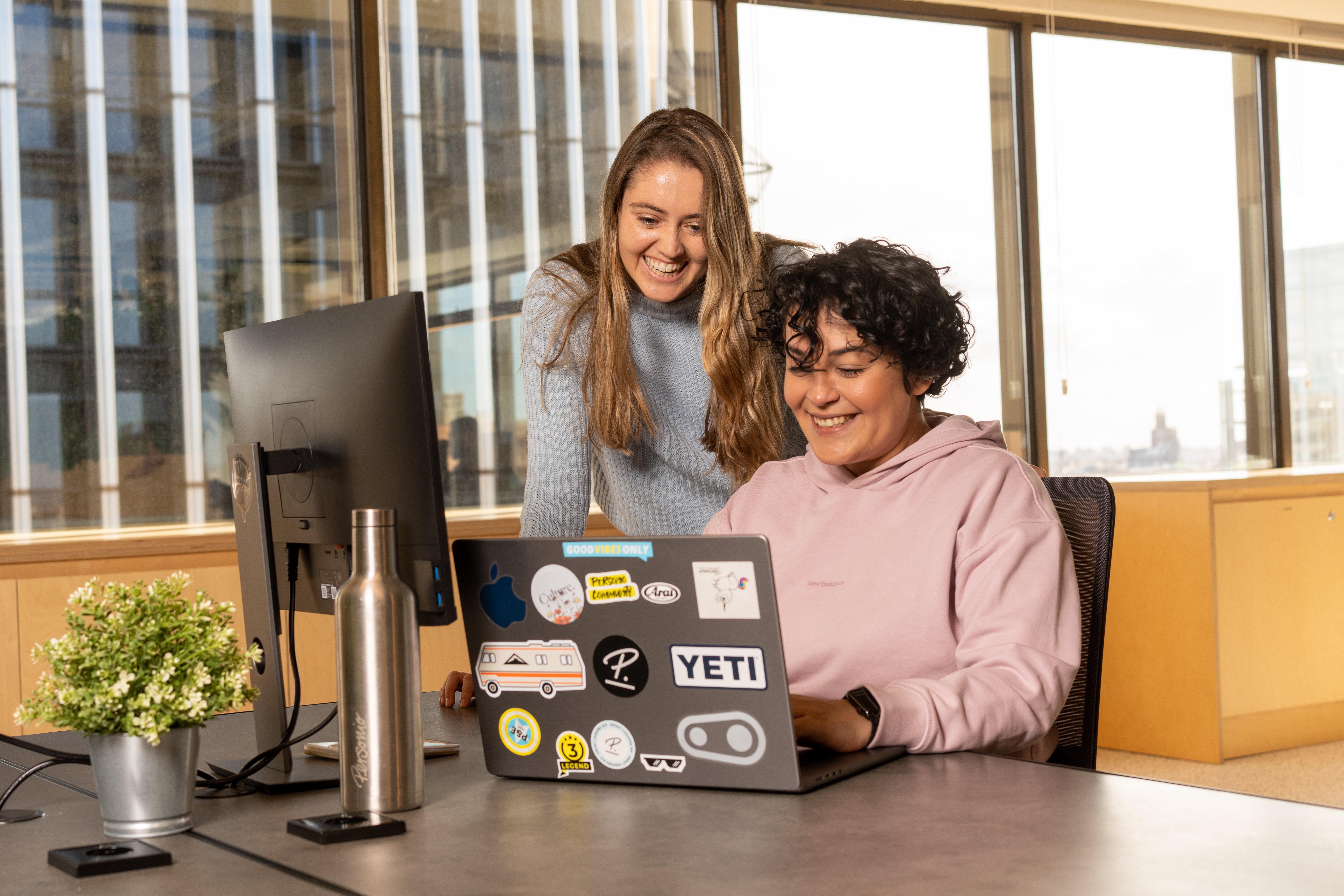 Two Personios looking at laptop in Madrid Office