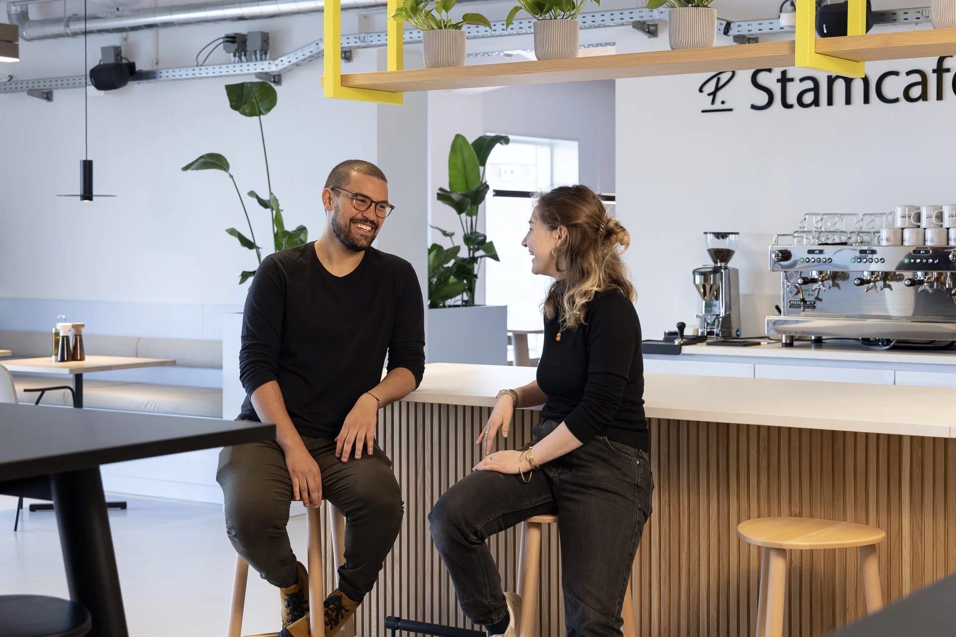 Two Personios smiling at each other in AMS Office StamCafe
