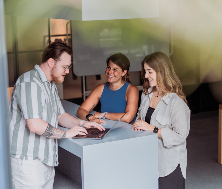 3 Personios around standing desk with laptop