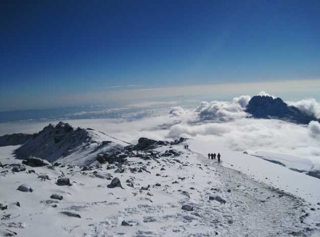 Trekkers descending after the summit with the glorious view of Mawenzi peak. 