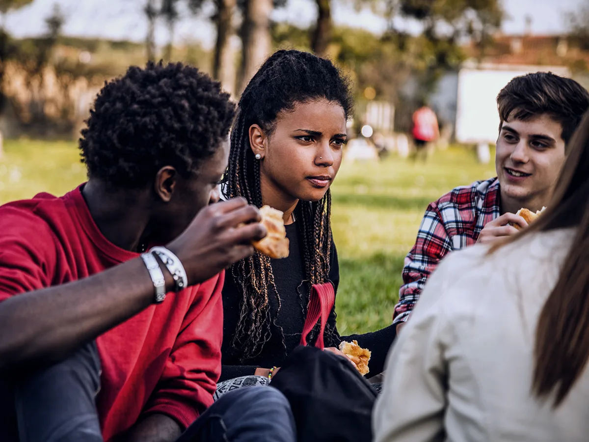 What is auditory processing disorder? A group of friends sitting outside having a picnic and conversation. 