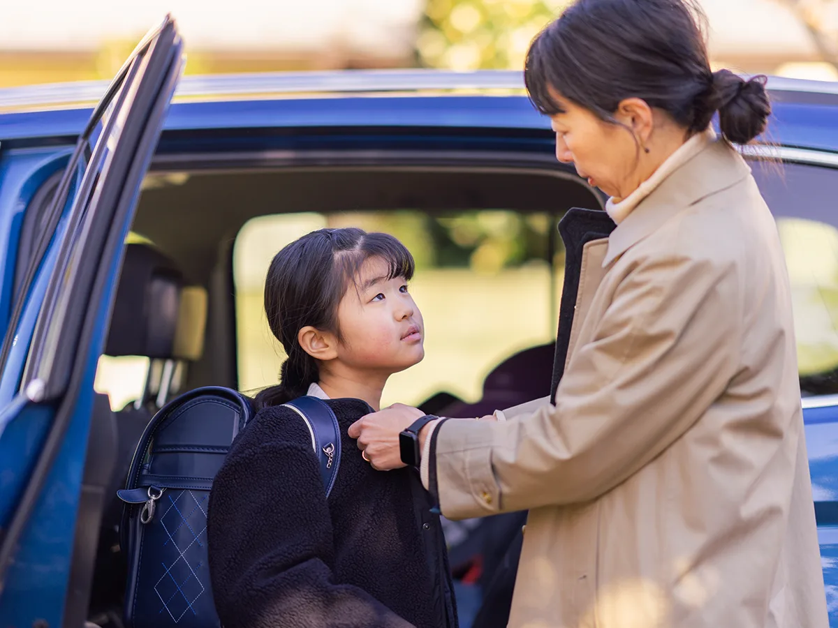 What to say when your child doesn’t want to go to school. Mom talks to child outside of car before school. 