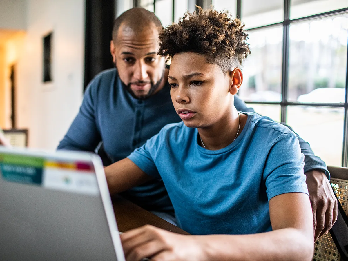 SAT or ACT: How to know which is best for your child, son and father talking while looking a laptop