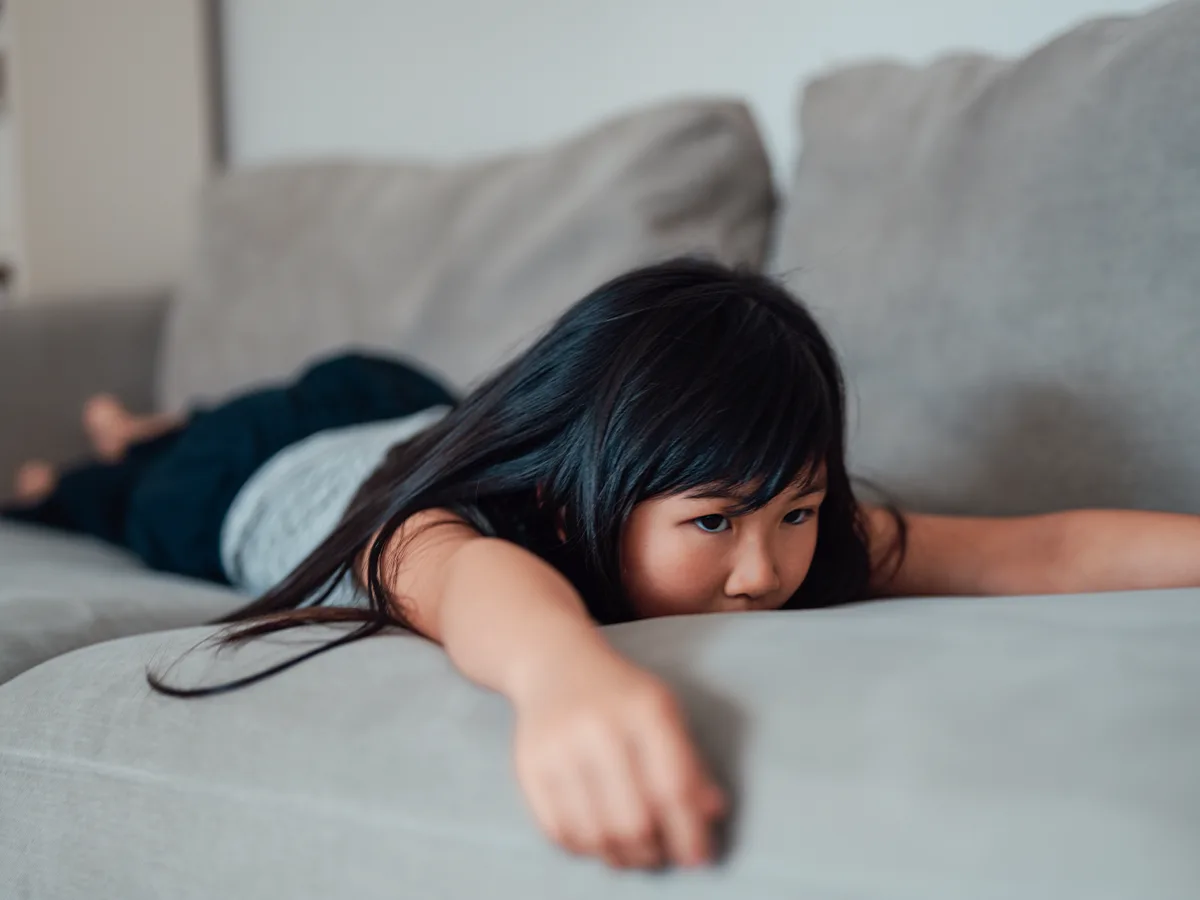 Why kids with executive functioning issues have trouble starting tasks, girl laying on a couch