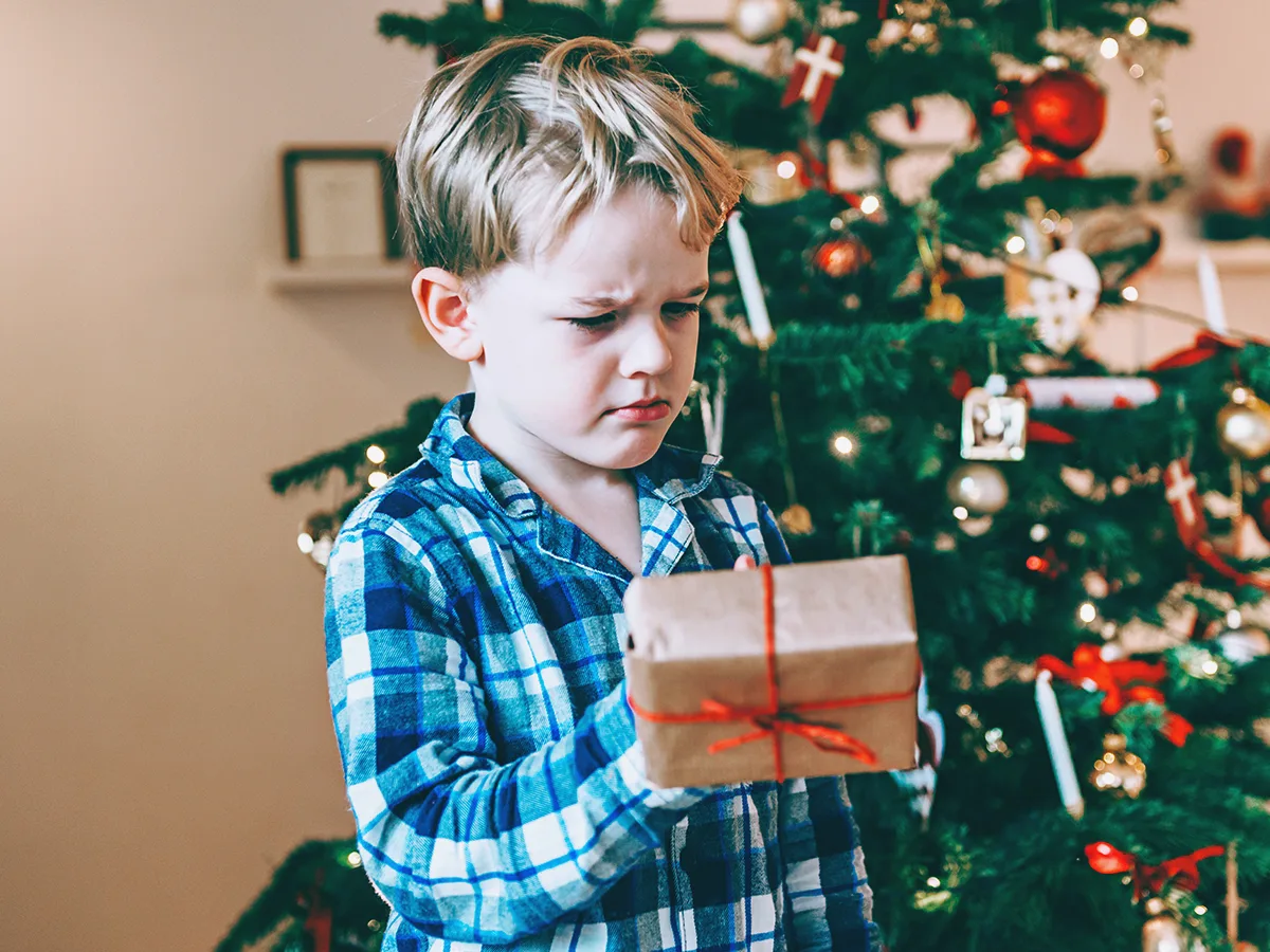 Why kids have tantrums when they get gifts, kid upset holding a present
