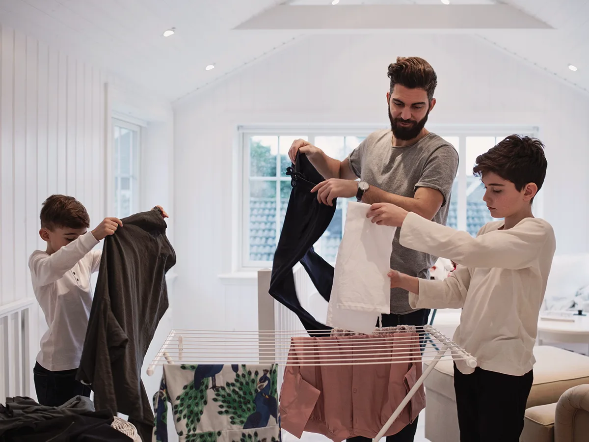 Why chores are good for your child, dad and sons folding laundry at home