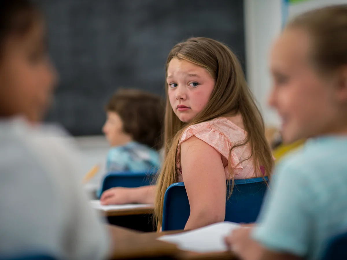 5 reasons why kids with ADHD get bullied, girl sitting in class