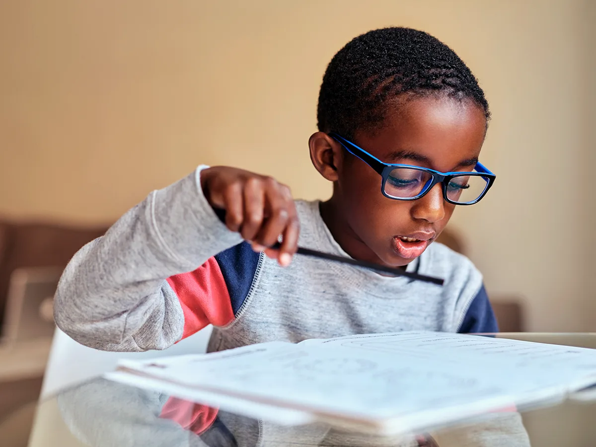 8 reasons kids might read slowly. A young child reads their homework. 