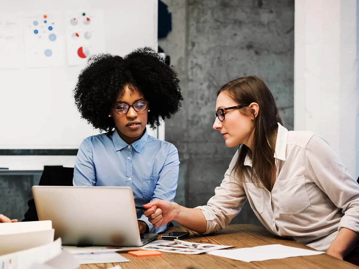 Word Prediction Technology: What it is and how it works, two women in a conference room working on a laptop 