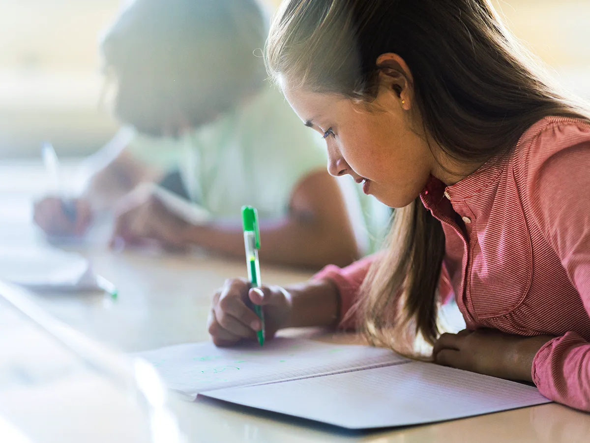 Paragraph shrinking: An evidence-based literacy strategy, girl highlighting in notebook in class