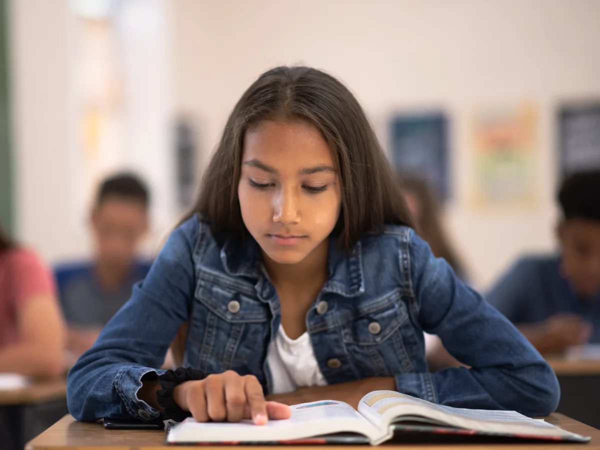 Teaching teens who struggle with reading: What can help. A teen reads in class.  