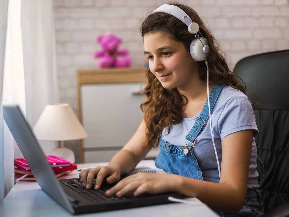 Free assistive technology tools on the web to help with reading, writing and math. A girl uses headphones for her laptop. 
