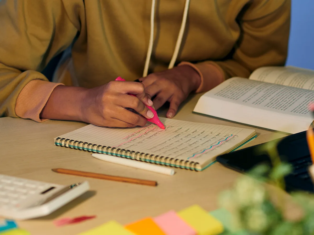 How to help teens develop good study habits. A teen highlights their notes from school.  