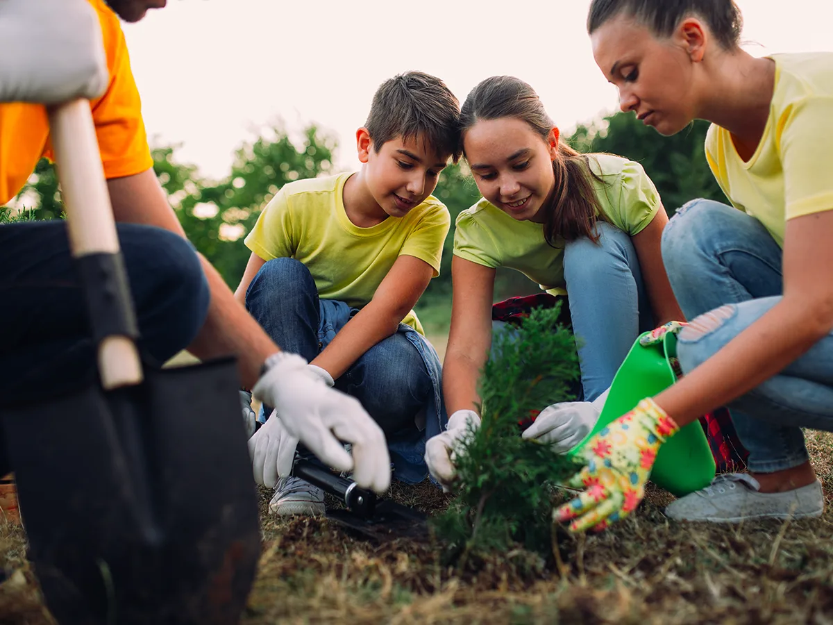 What to do when your tween or teen is lonely. A group of teens plant a tree together. 