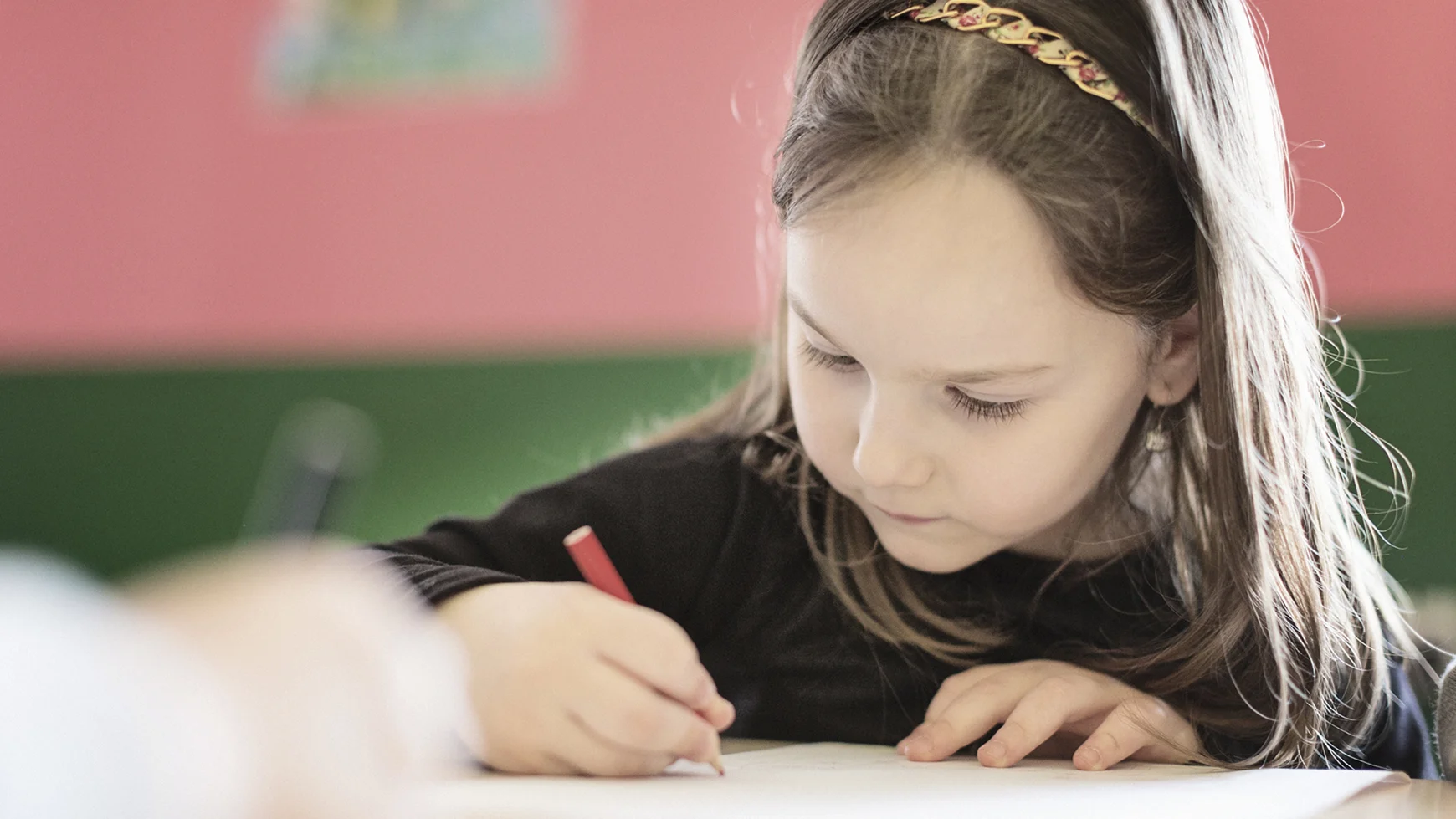 A child smiling with school supplies and an adult smiling at them. 