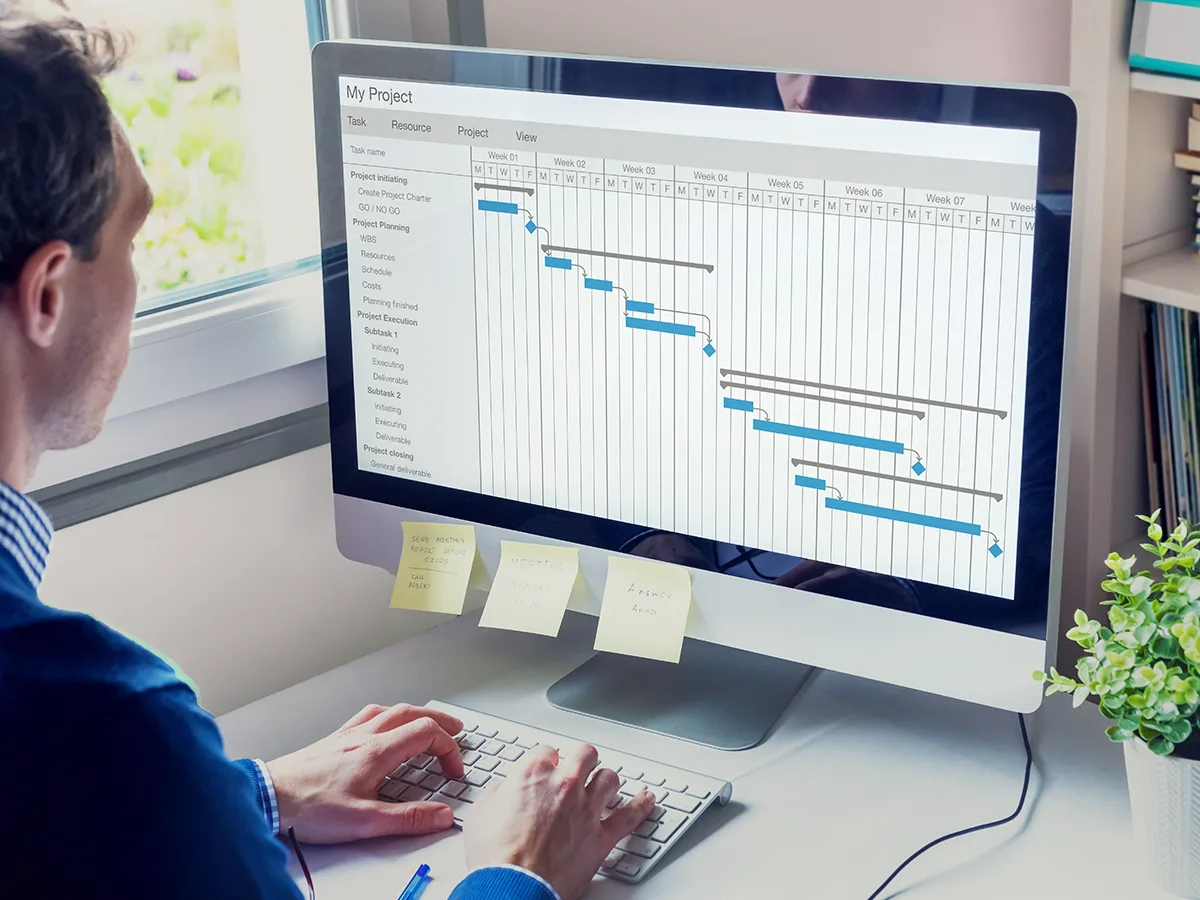 Following instructions and managing deadlines, man working on a computer calendar