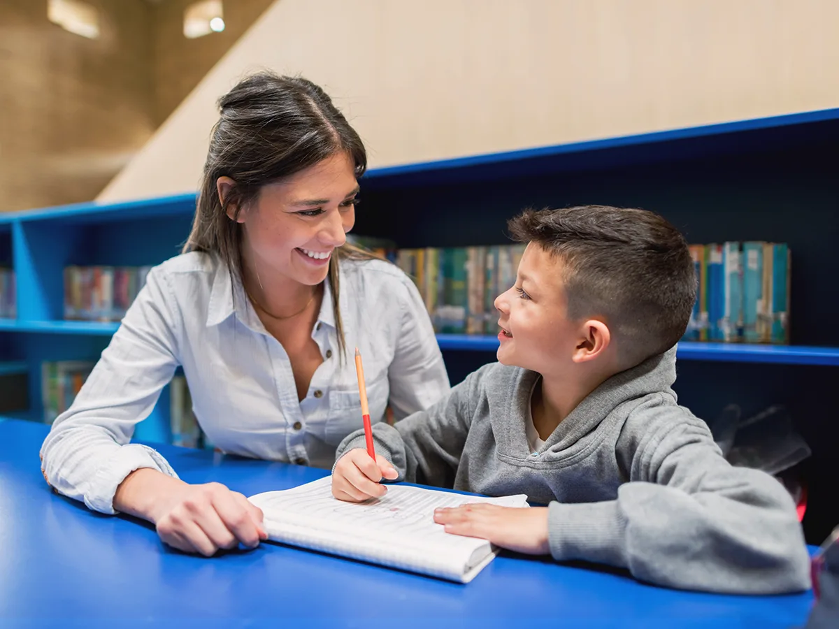 An adult helps a student with classwork. 