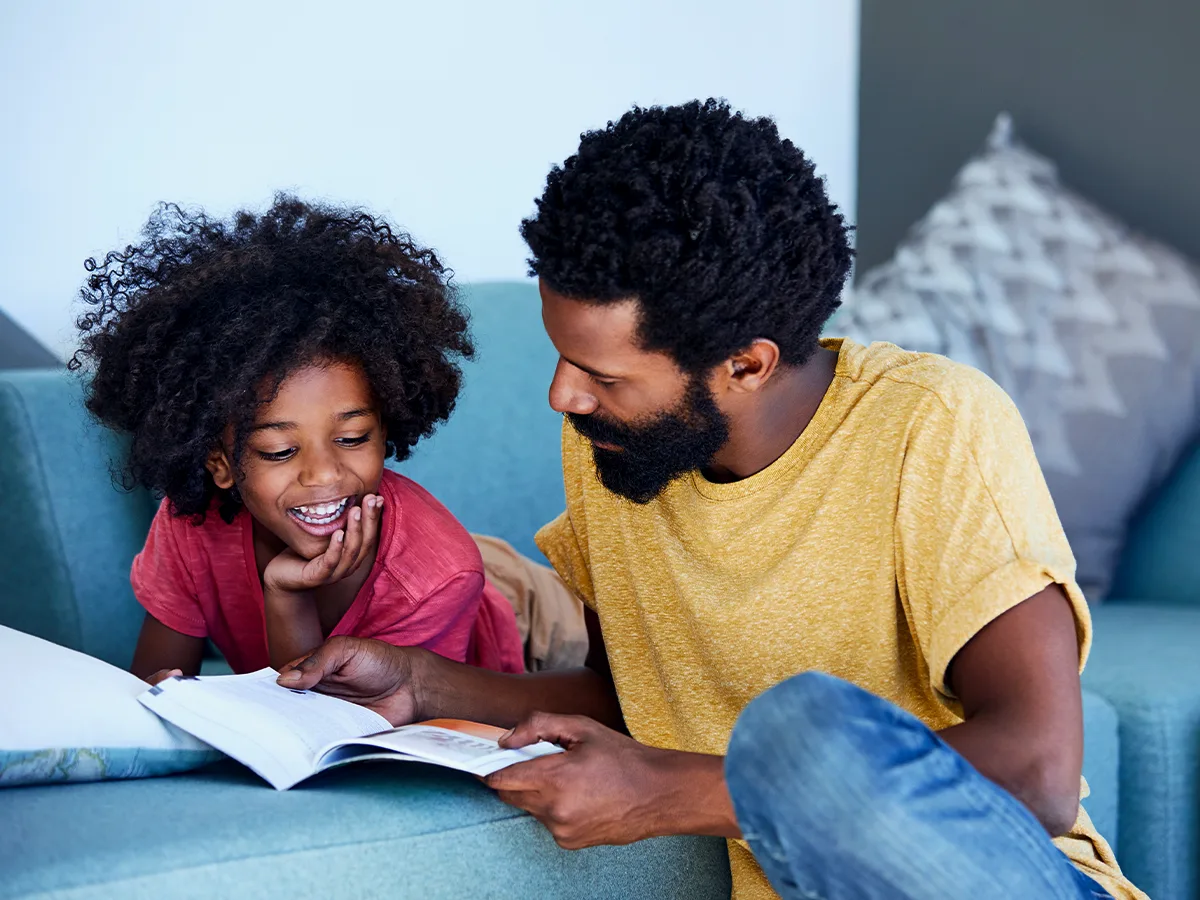 4 reasons to keep reading to your grade-schooler. A parent is reading to their young child. 