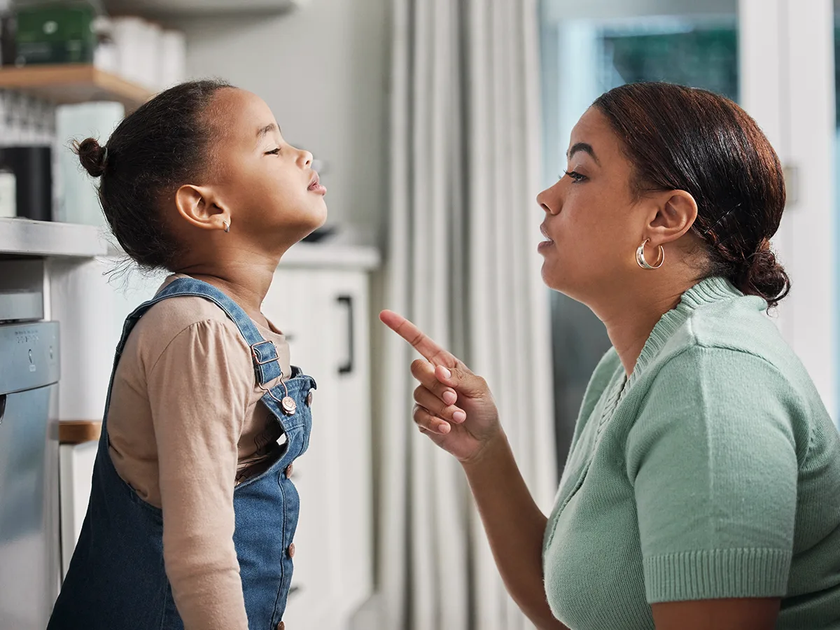The difference between disruptive behavior disorders and ADHD, mom crouched down to talk to her daughter at home.