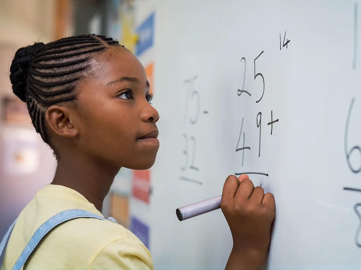 what is number dyslexia? A girl solves a math problem on a whiteboard in class. 