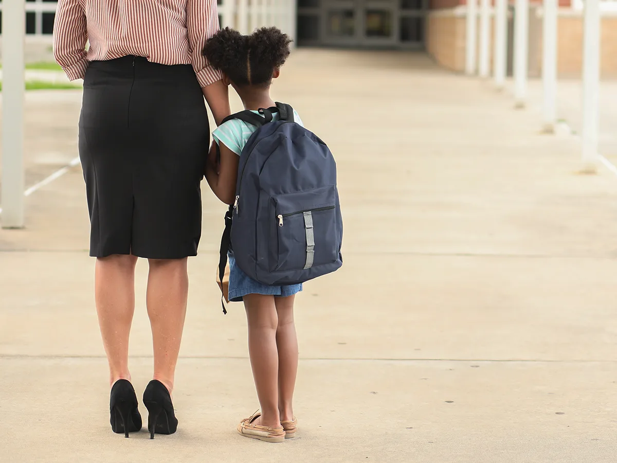 10 Ways to Help Shy Kids Speak Up for What They Need, girl walking into school with mom 