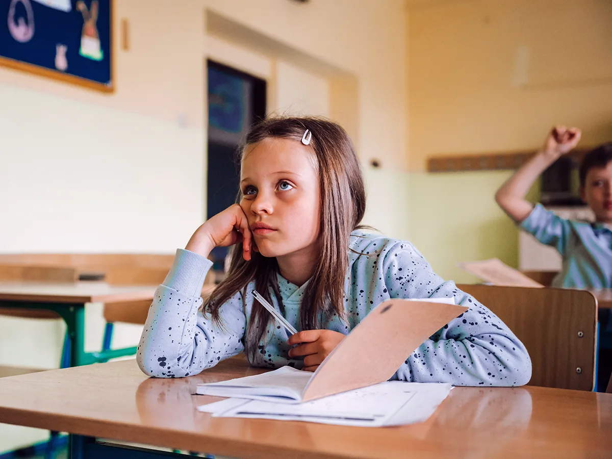 A student looks bored in a classroom. 