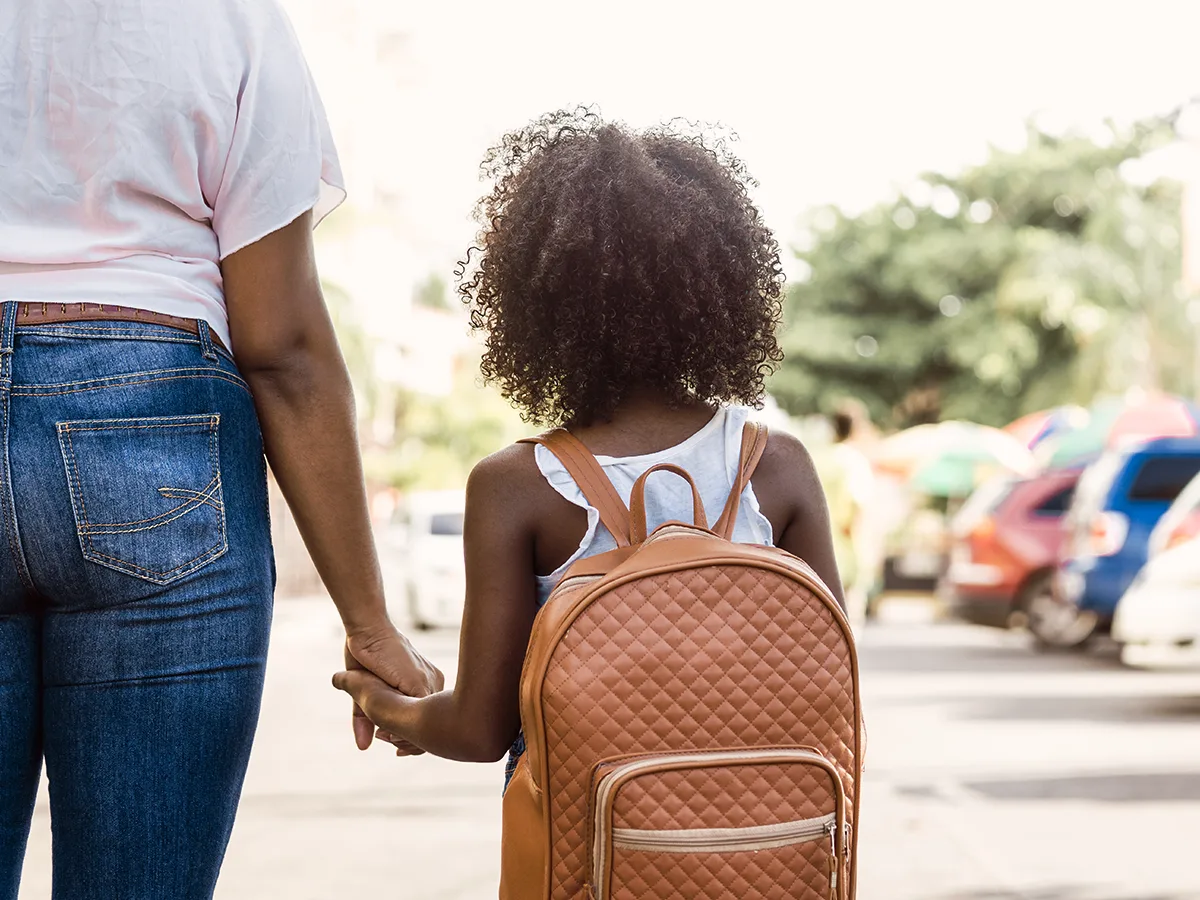 What to do if your child is losing IEP services, child with a backpack holding her mothers hand walking to school