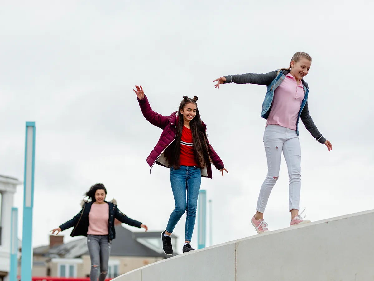 Why teens with ADHD may take more risks, girls walking on a wall ledge