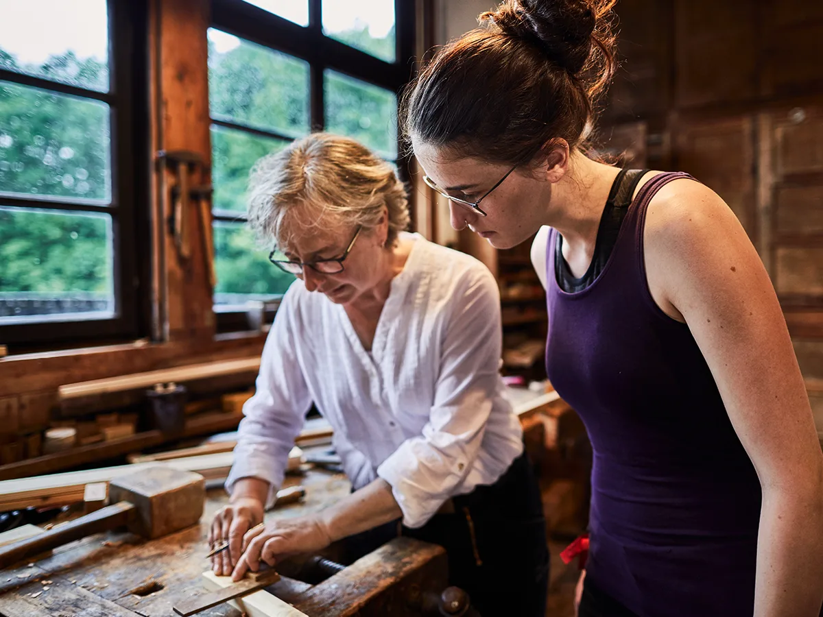After high school: Different ways to thrive, girl learning on the job from a senior woodworker