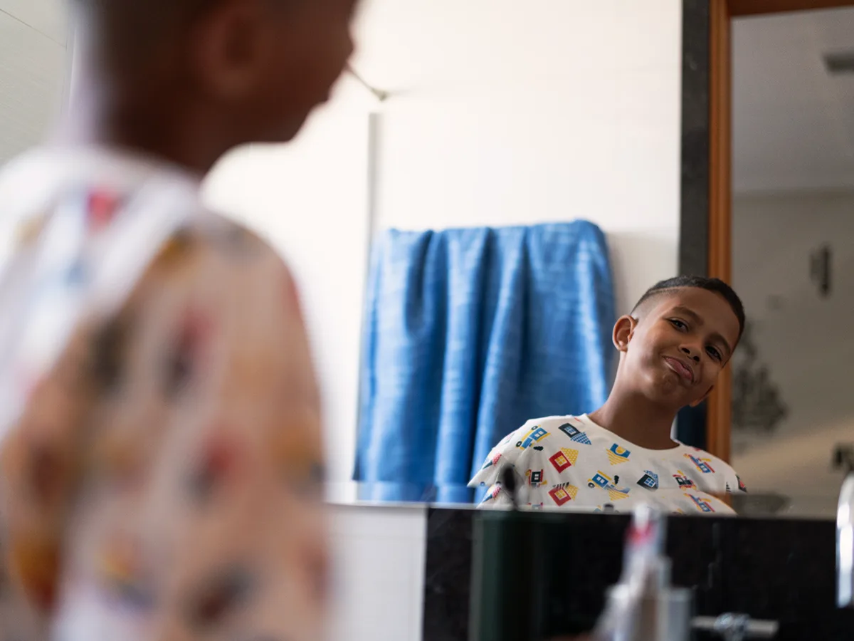ADHD and wishful thinking in kids, young boy looking at himself in the mirror in his pajamas