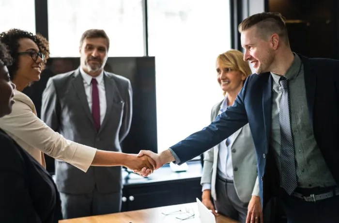 People shaking hands at a meeting