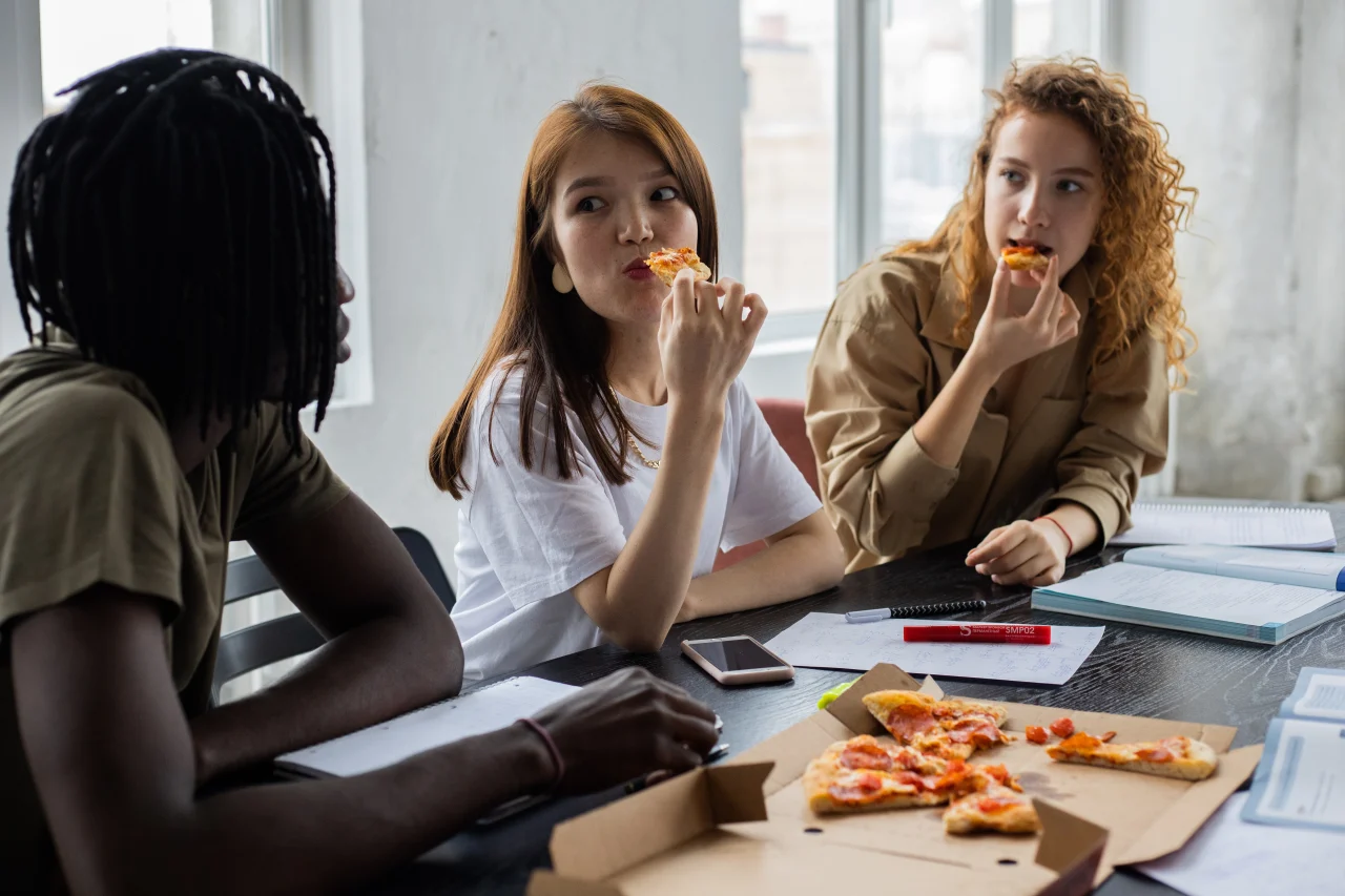 Leute essen Pizza während eines Meetings
