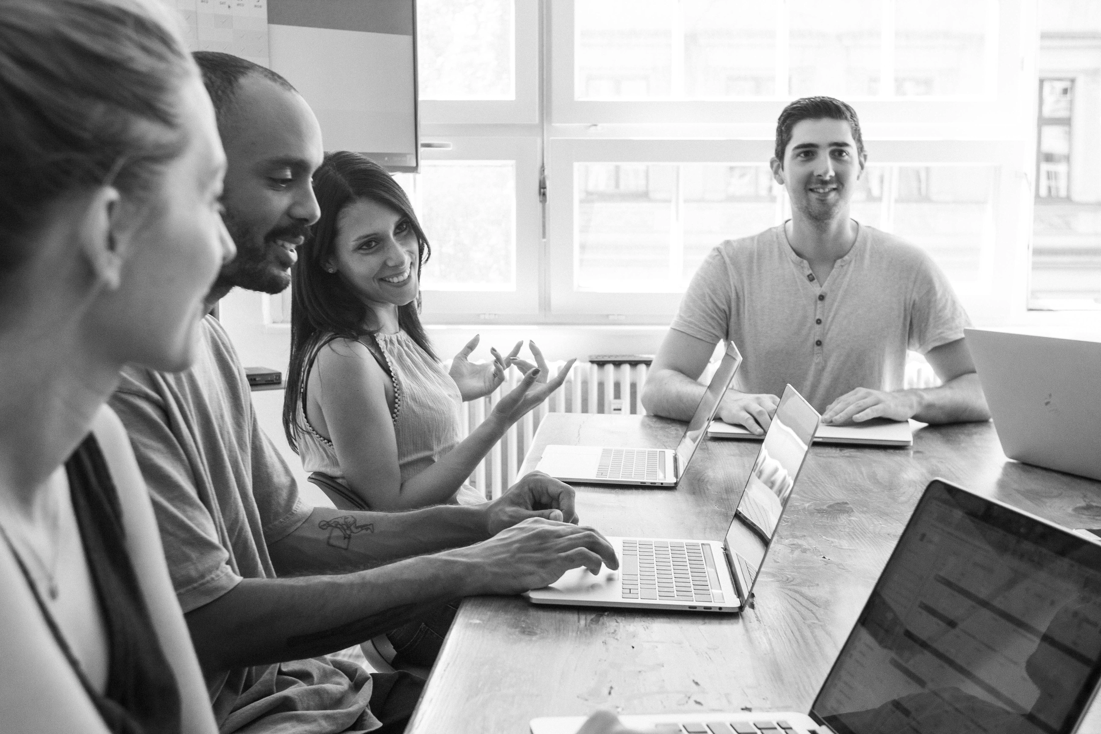 Four happy people sitting in a meeting room and work