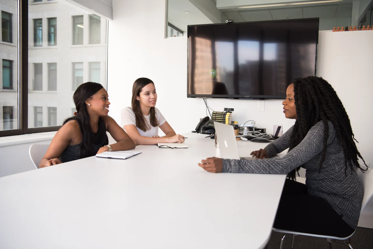 Three people sitting at two sites of the table in a job interview