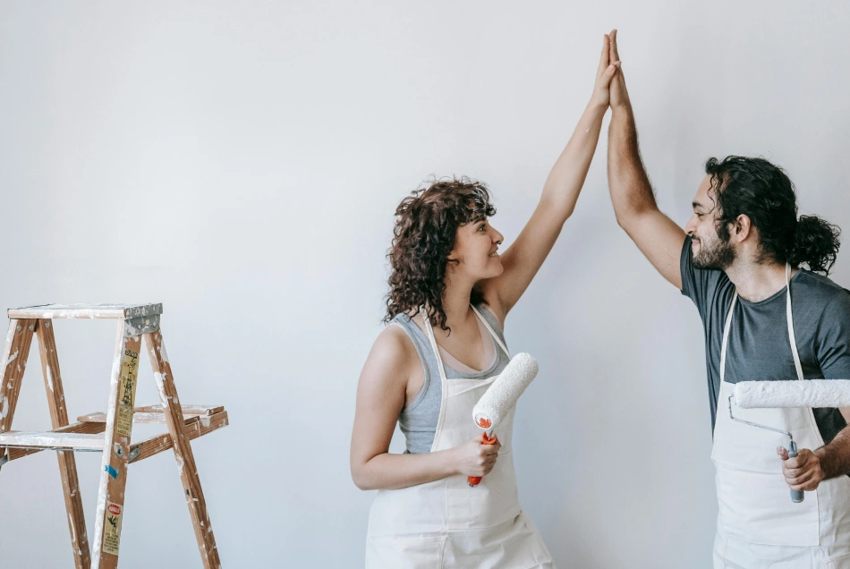A couple renovating their home is doing a high-five.
