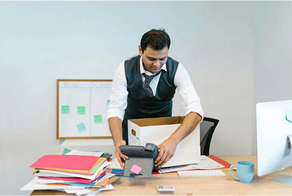 A man is cleaning and organizing his desk