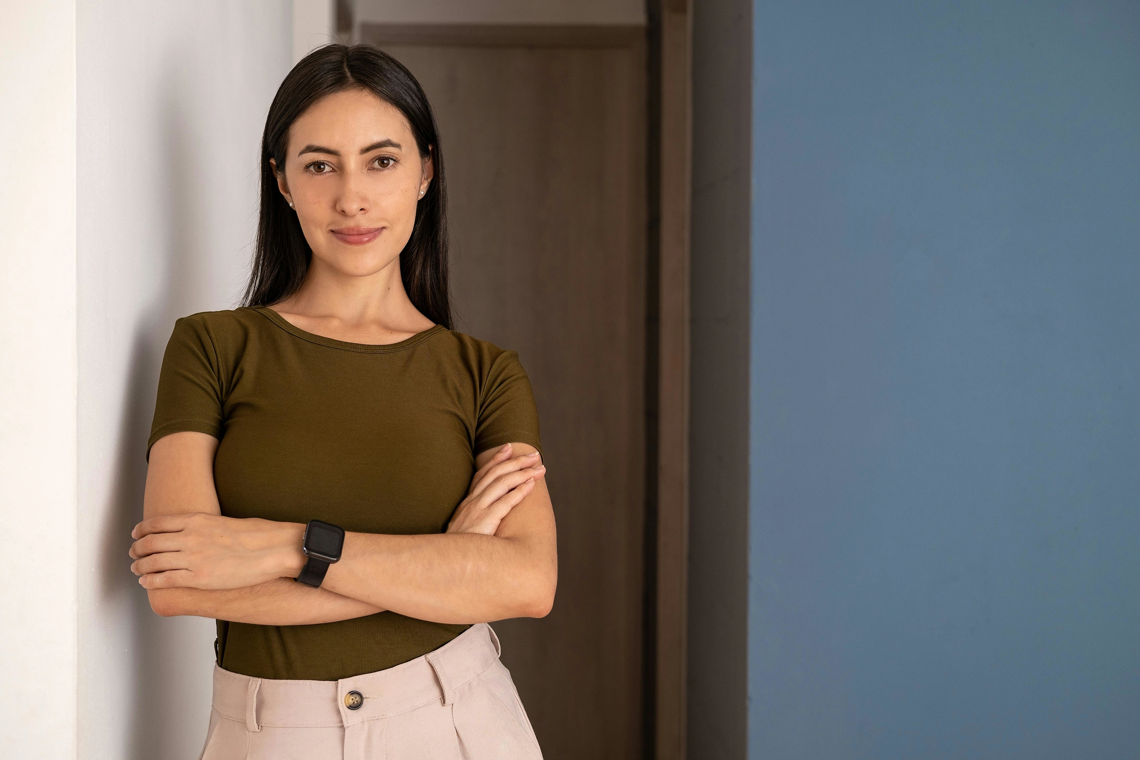 Confident professional standing with folded arms.