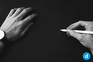 Hand hält weissen Stift vor einem schwarzen Hintergrund