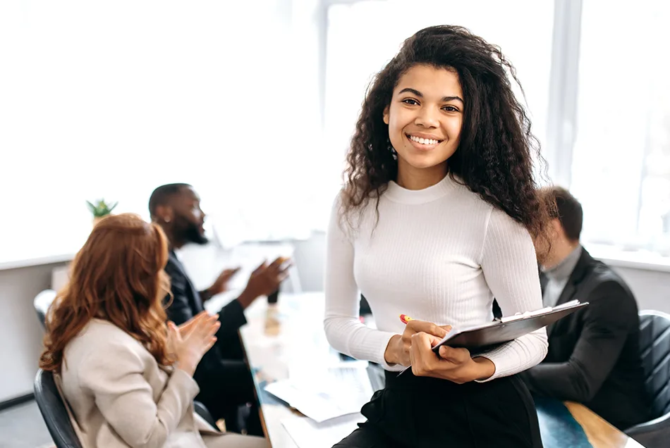 woman on desk with group in background