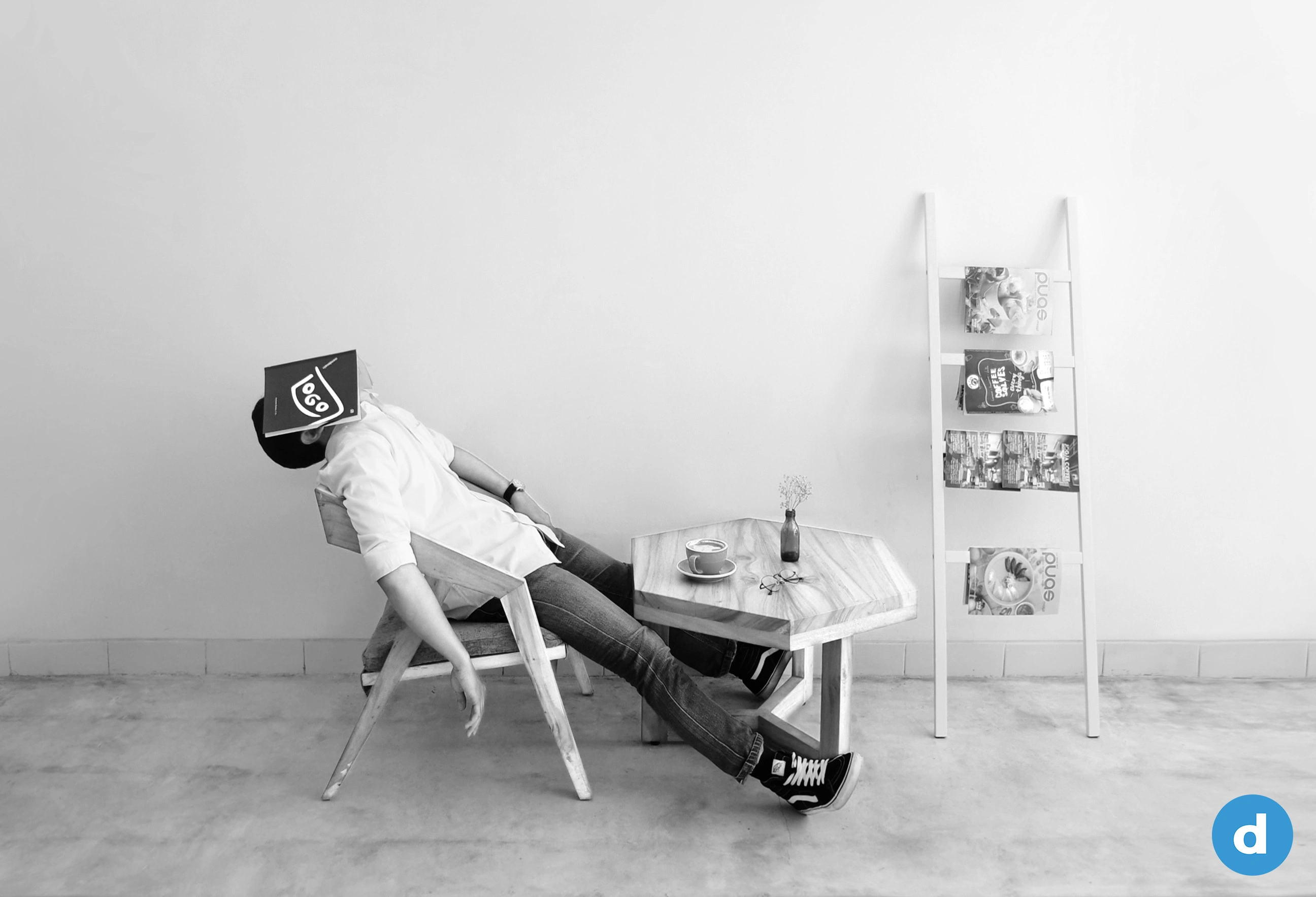 Annoyed person sitting on a chair with a book pulled over his face.