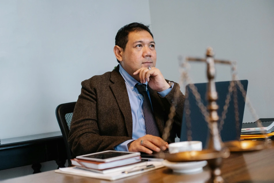A business man is working by his desk and thinking.