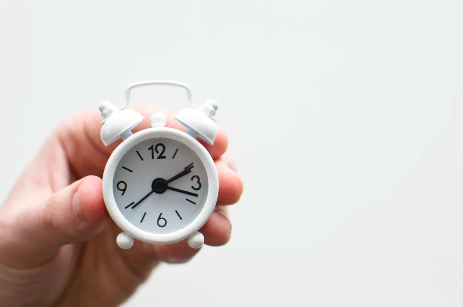 Hand holding an alarm clock