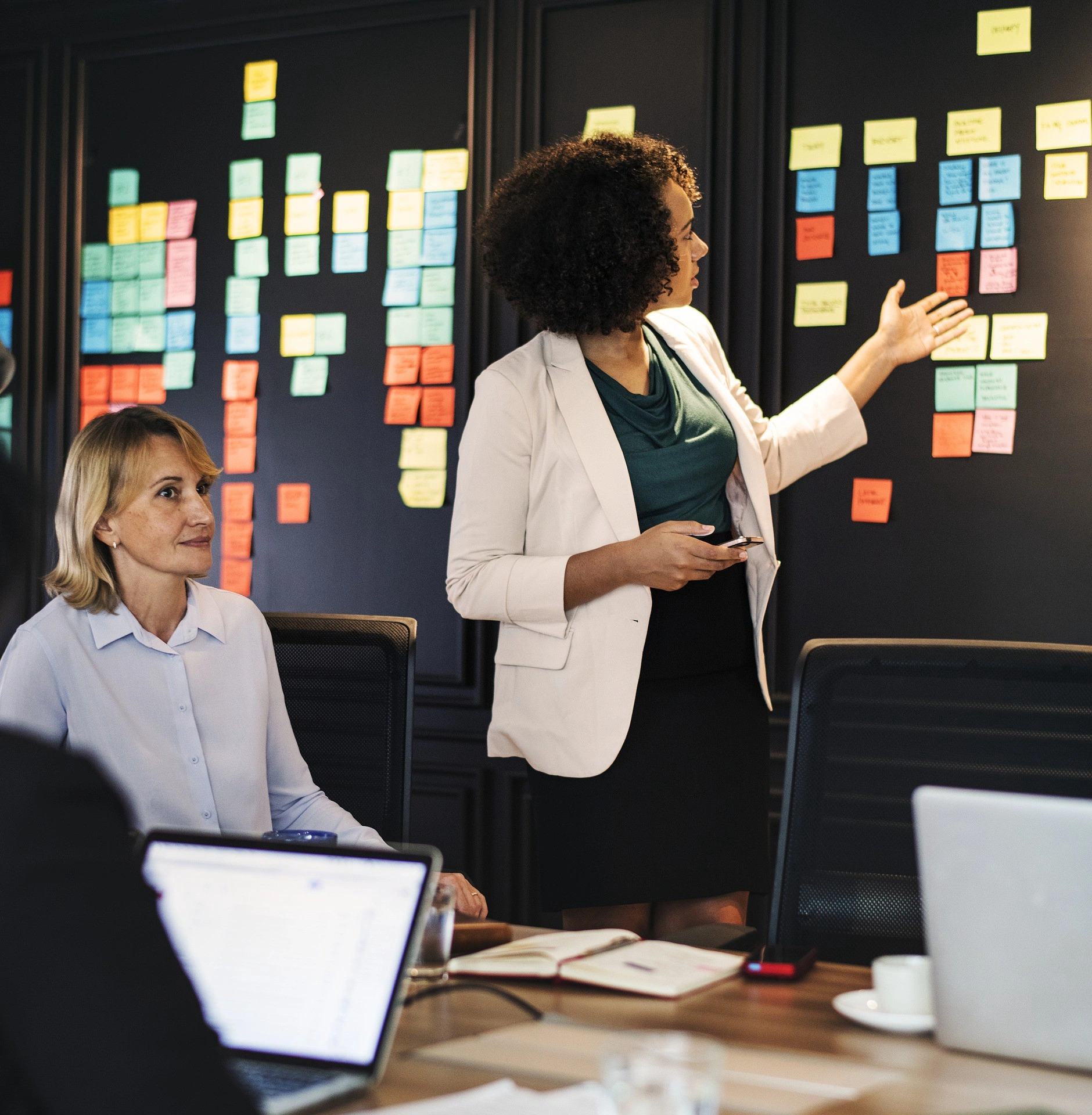 Two people in a meeting looking at their notes