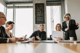 A group of people in a room discussing during a board meeting